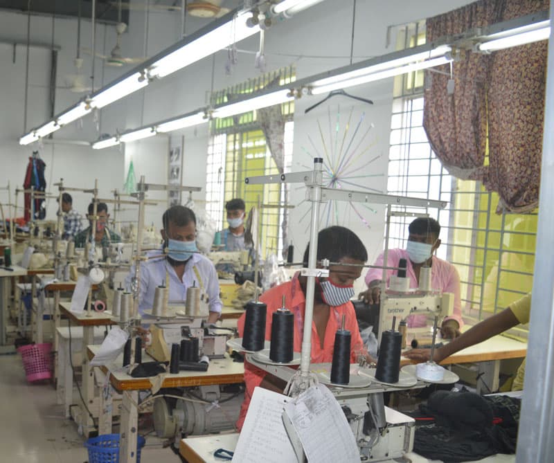 Operators at industrial sewing stations on the production floor